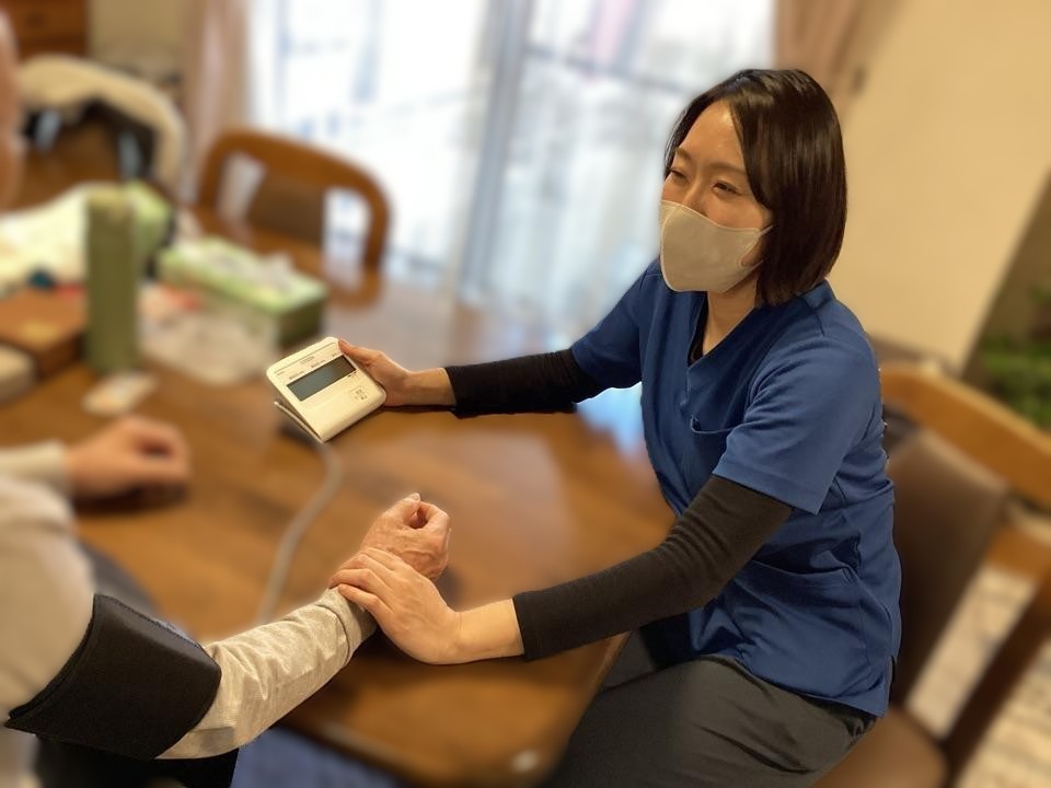 訪問先で利用者様に向き合う看護師